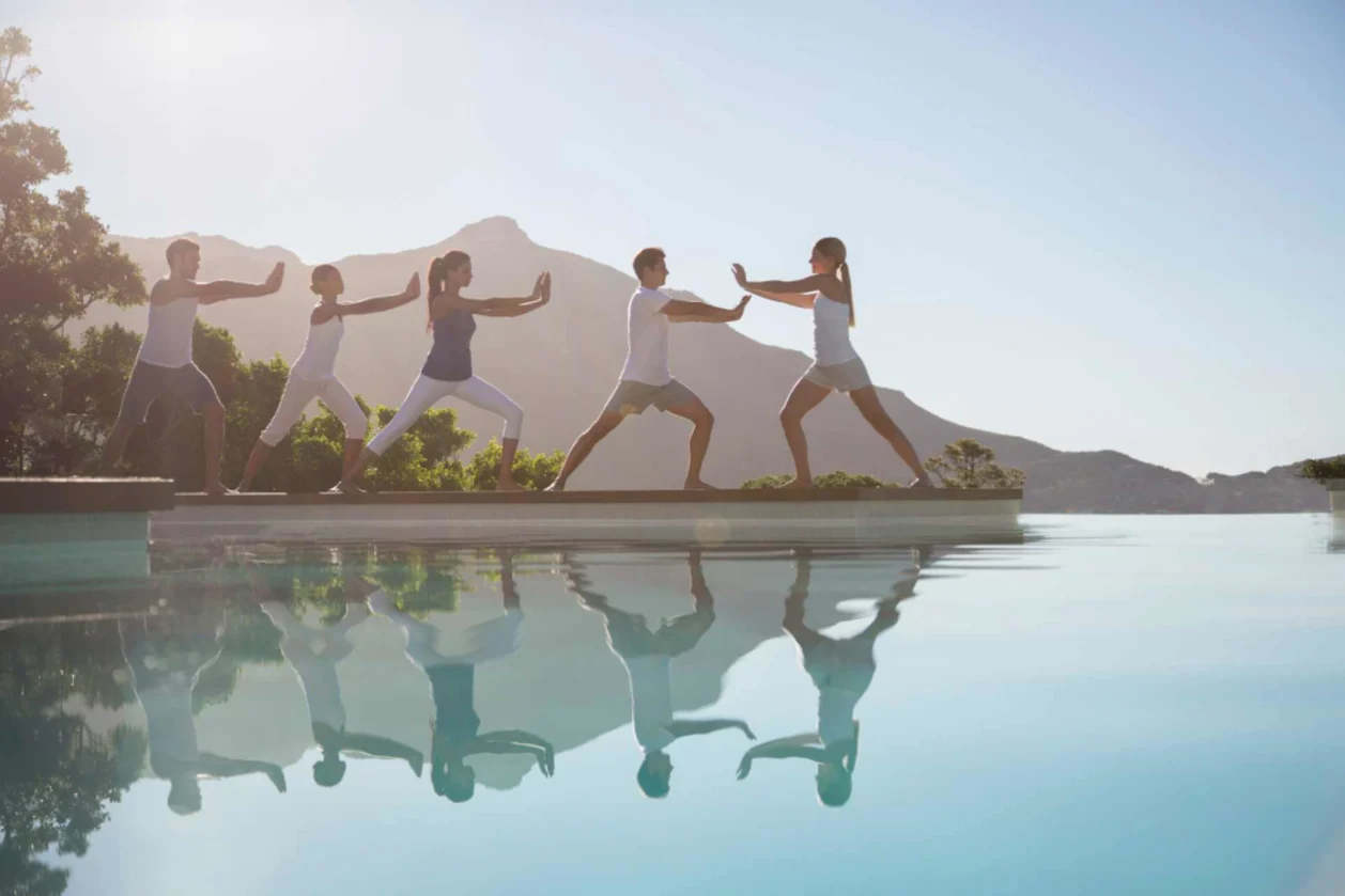 People practicing tai chi poolside